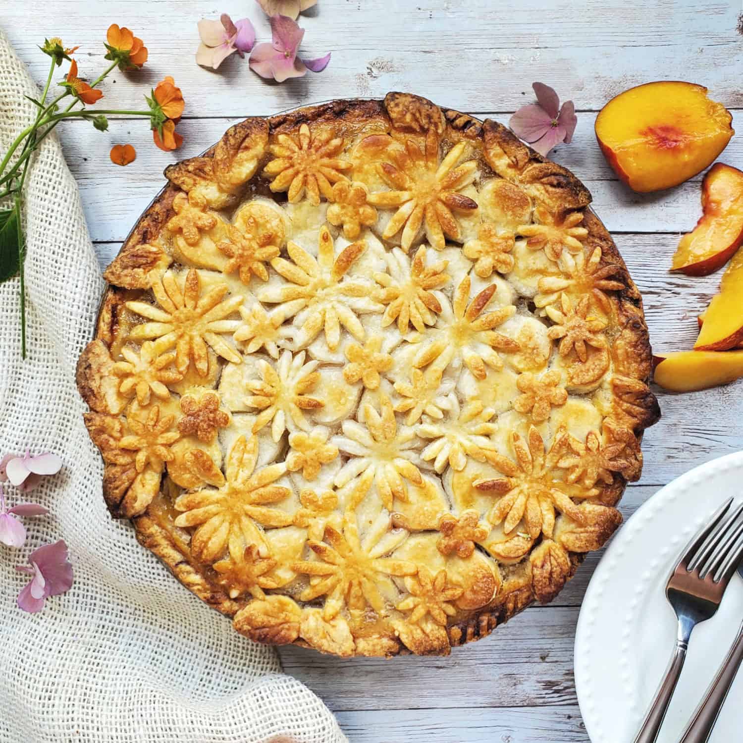 Perfect Peach Pie: Fresh pick peaches baked with a splash of orange to brighten the flavor & adorned with easy to make pie crust flowers!